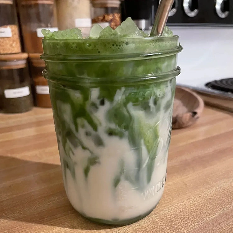 Customer testimonial photo of a jar of iced matcha latte with swirls of milk